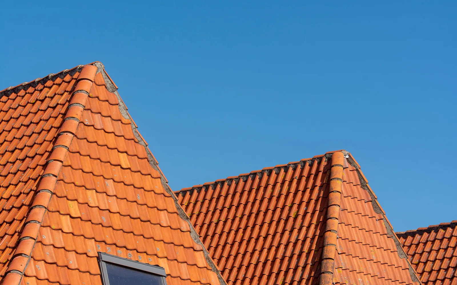 Toiture rénovée en tuiles plates après un chantier de réfection complète