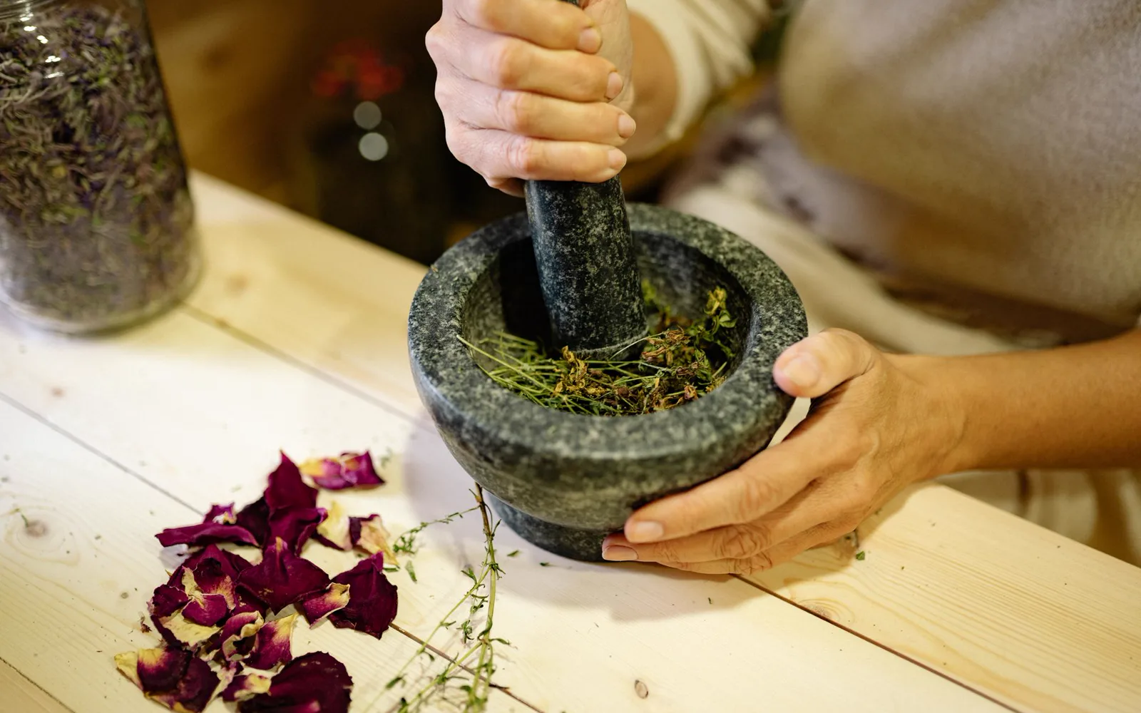 Naturopathe en consultation entourée de plantes et d'huiles essentielles dans un espace lumineux