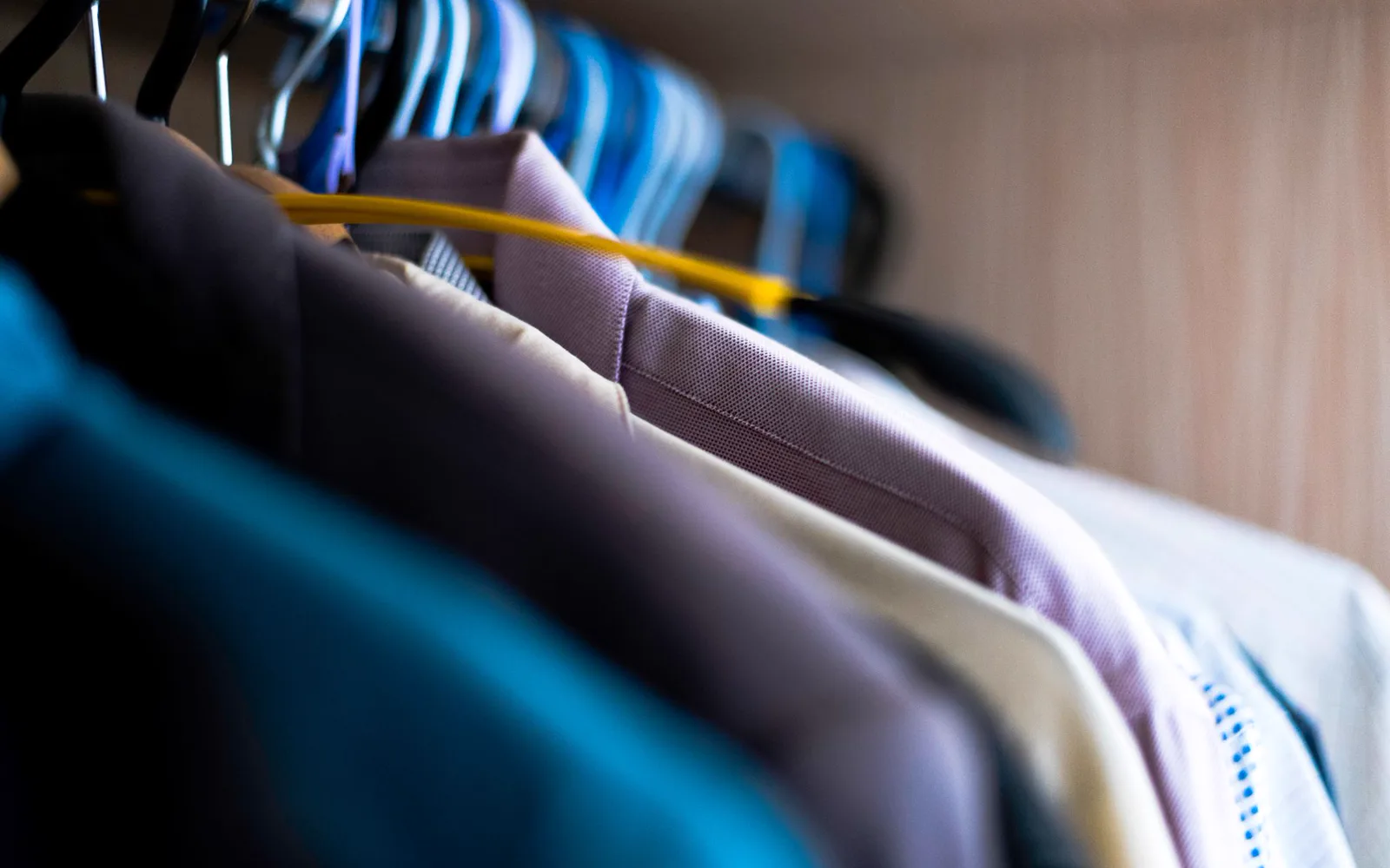 Vêtements soigneusement suspendus sous housses dans un pressing moderne