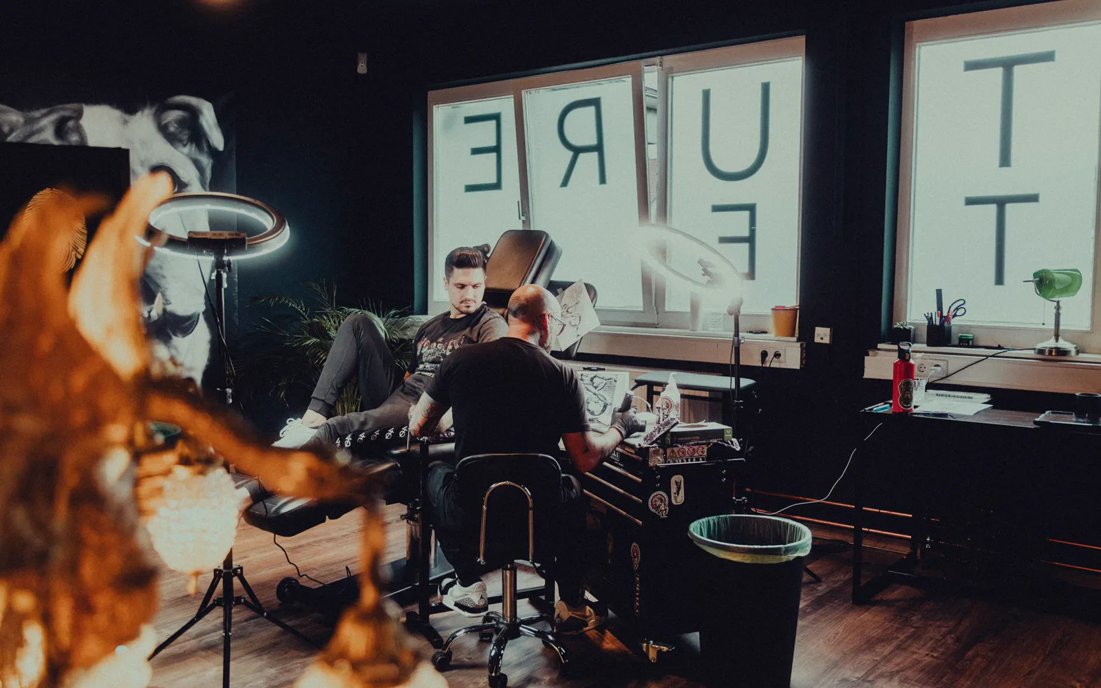 Artiste tatoueur au travail dans son studio, aiguille sur la peau du client