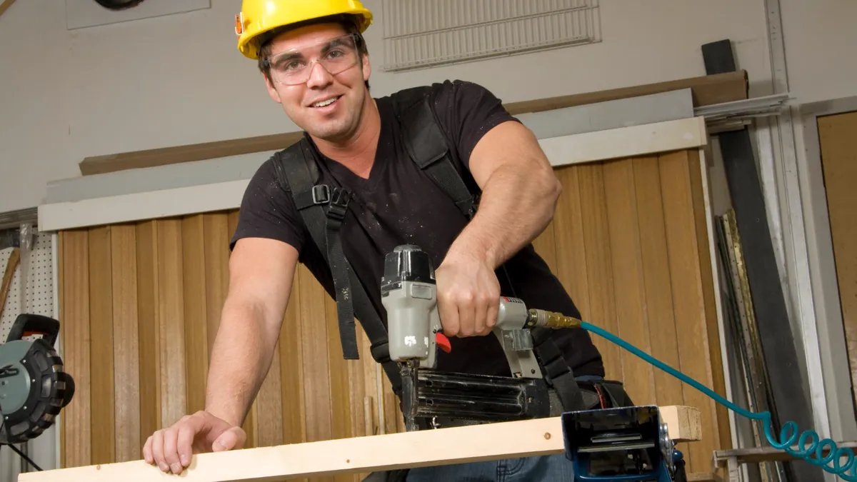 Menuisier utilisant un cloueur