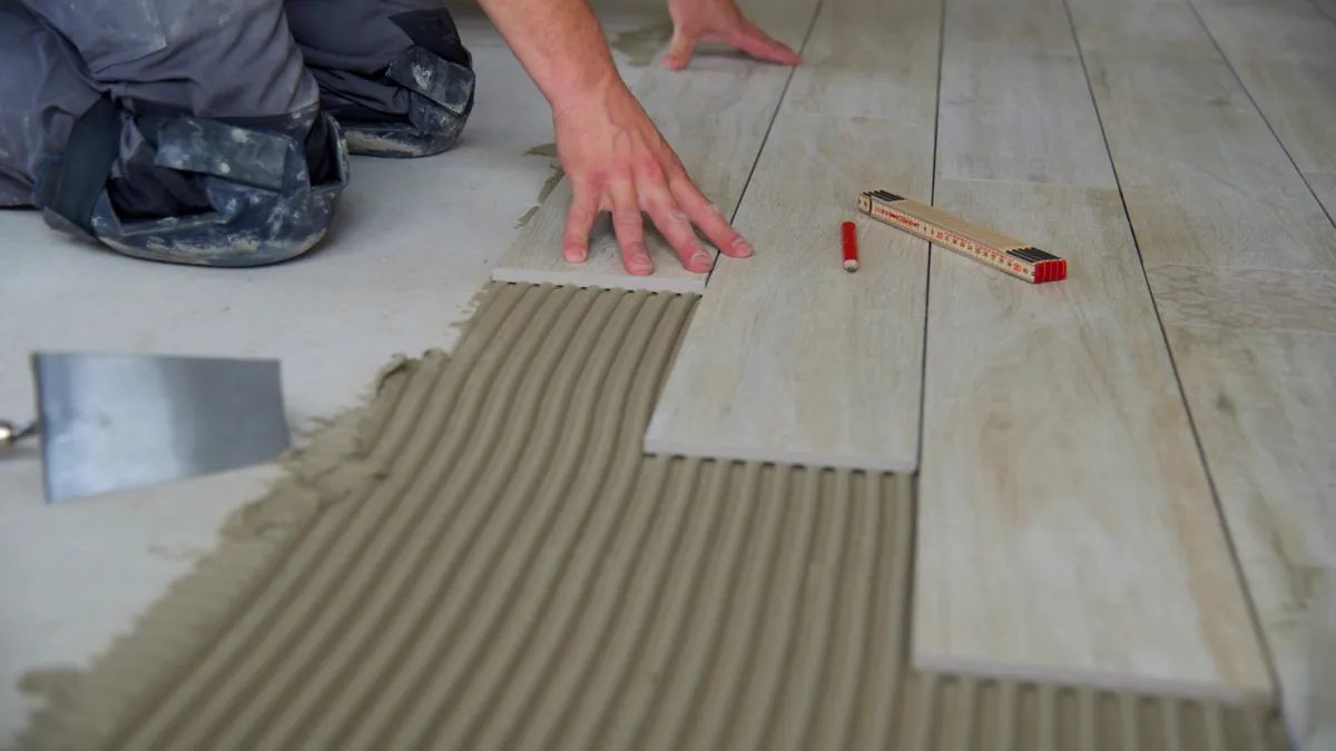 Carreleur posant un carrelage imitation bois sur lit de colle