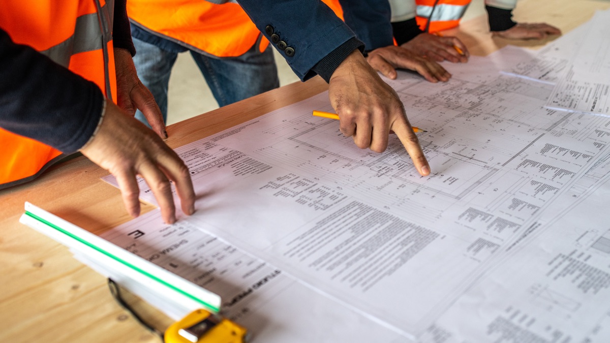 Mains sur un plan de chantier
