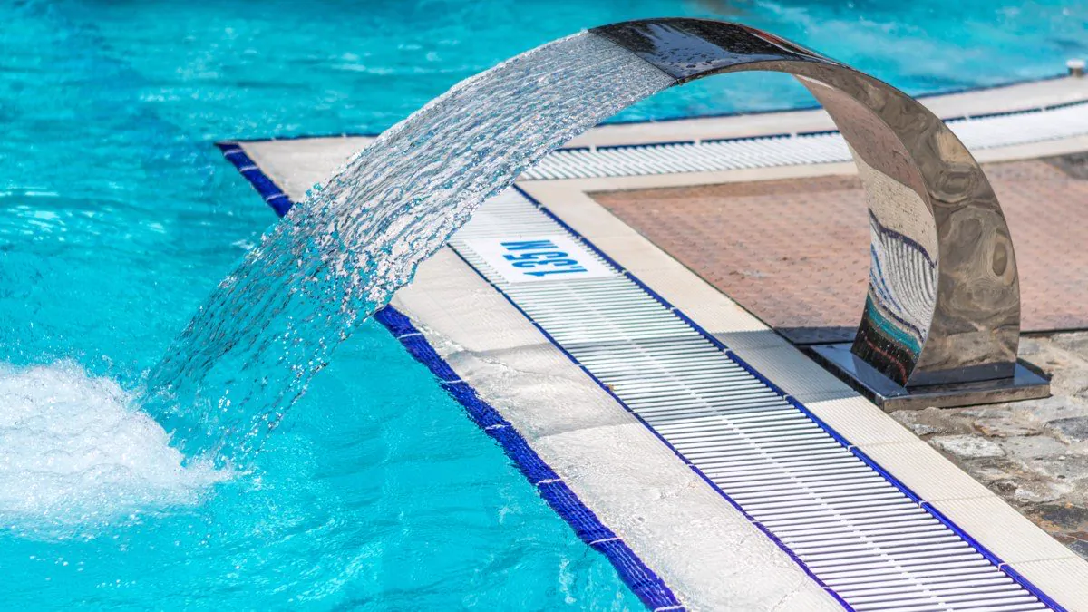 Cascade en inox déversant l’eau dans une piscine turquoise