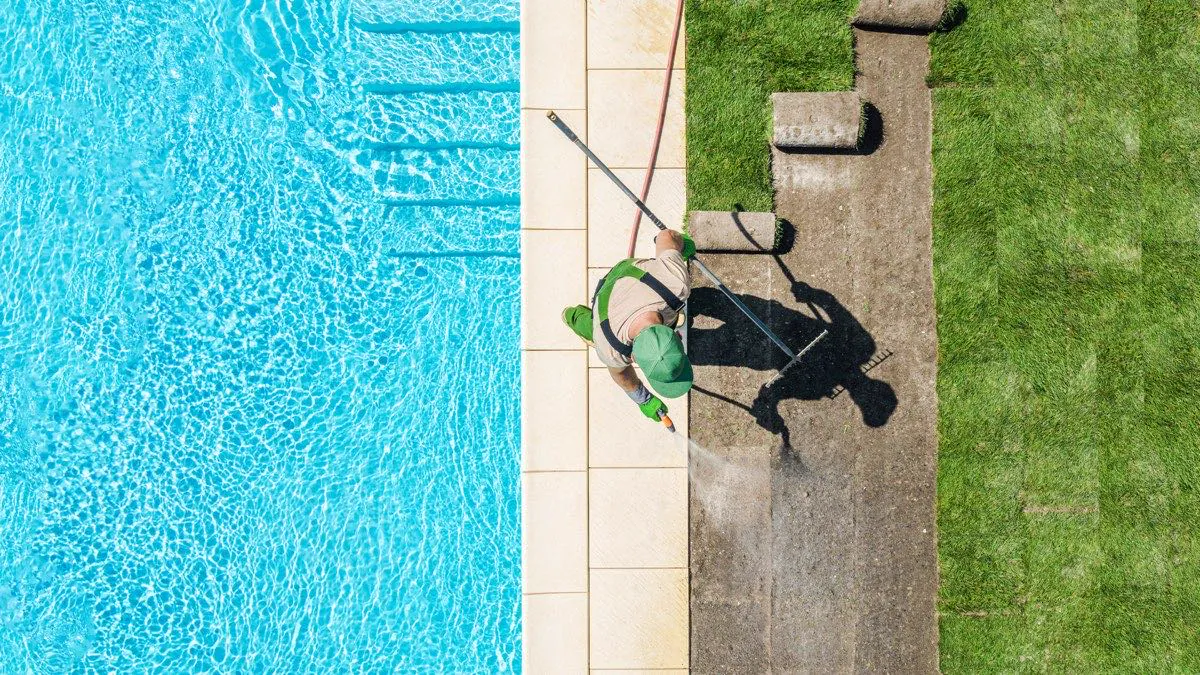 Professionnel aménageant les abords d’une piscine extérieure