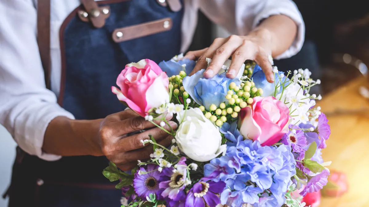 Fleuriste composant un bouquet coloré