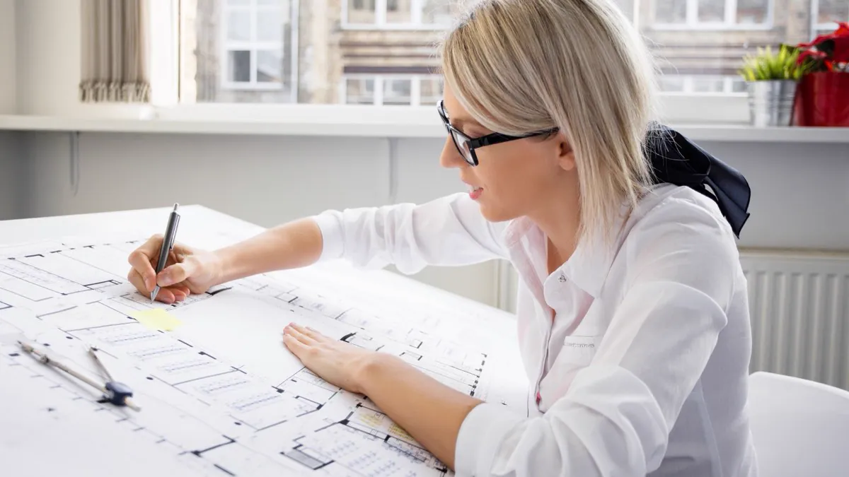 Architecte dessinant des plans de construction sur sa table de travail