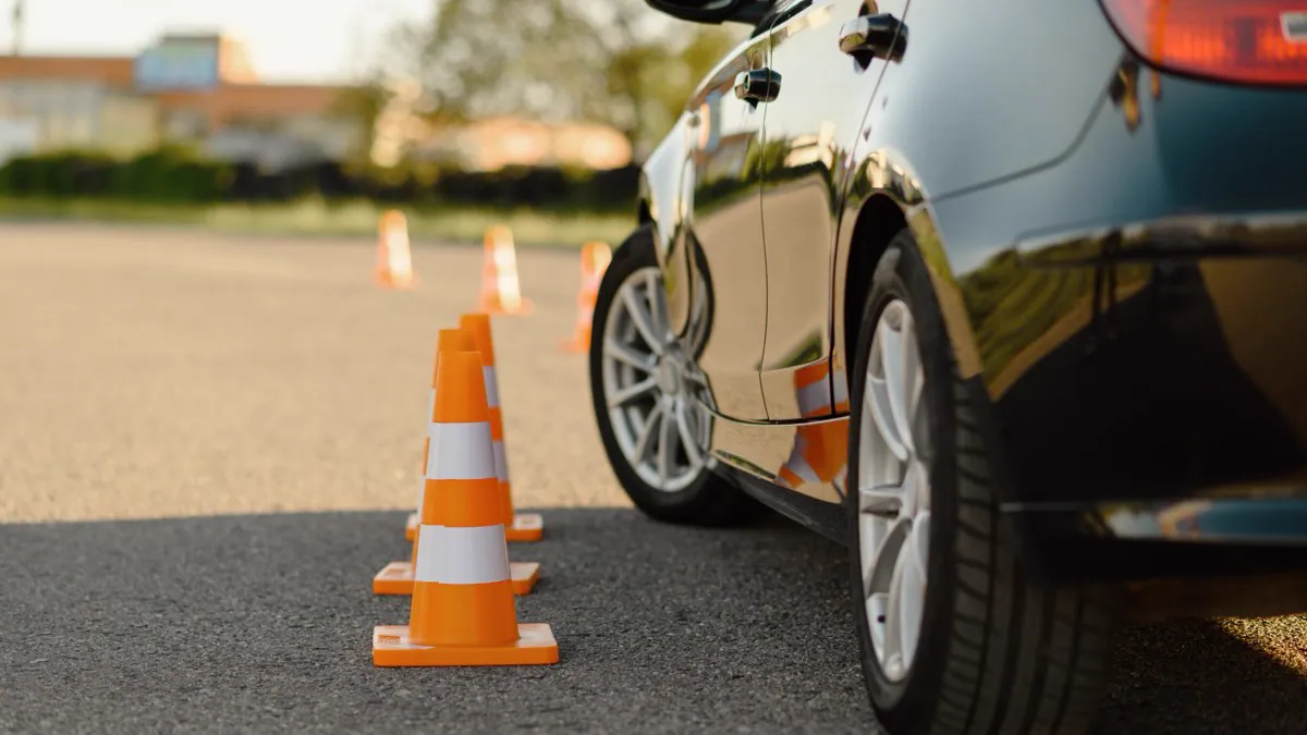 Plots de conduite alignés près d’une voiture d’auto-école
