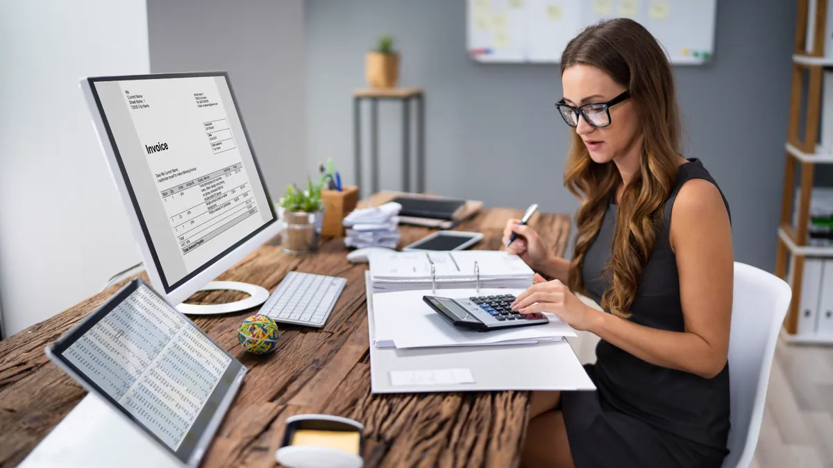 Comptable analysant une facture avec sa calculatrice