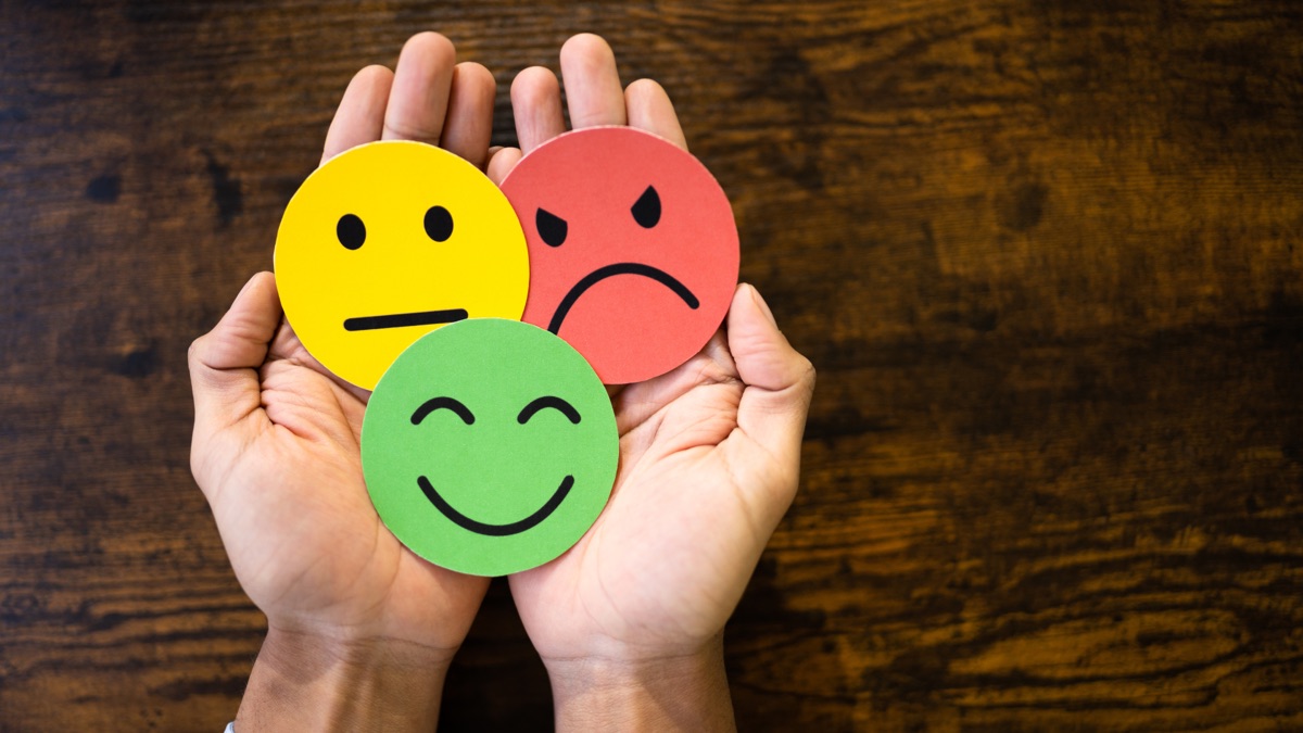 Mains tenant des visages souriants (satisfaction client)