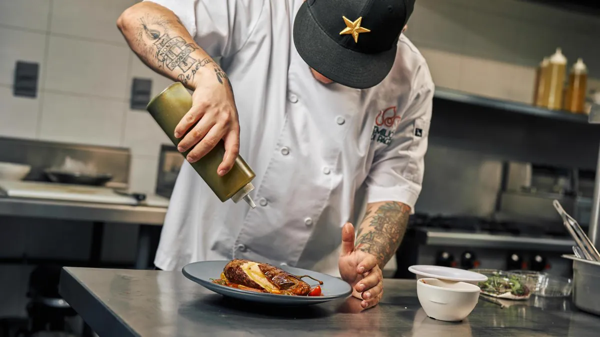 Chef dressant une assiette gastronomique en cuisine