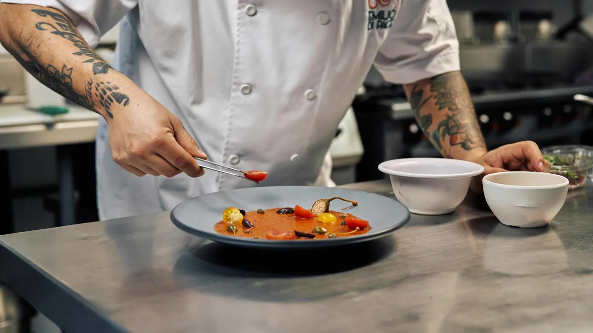Chef finalisant un plat gastronomique à la pince