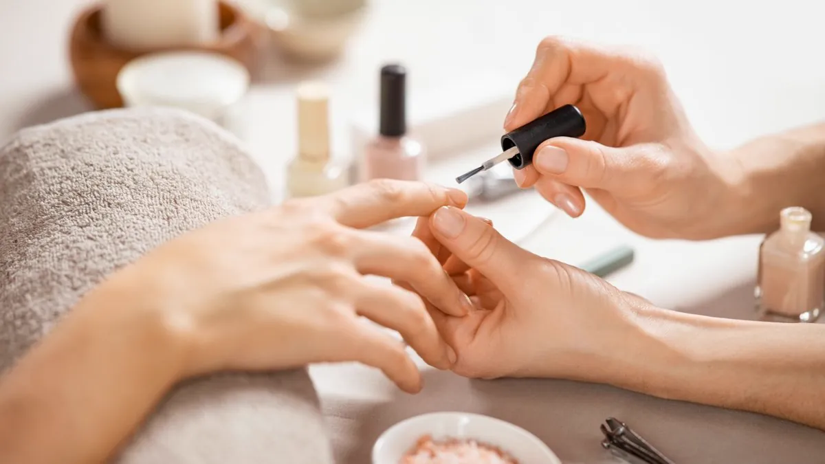 Pose de vernis au pinceau lors d’une manucure