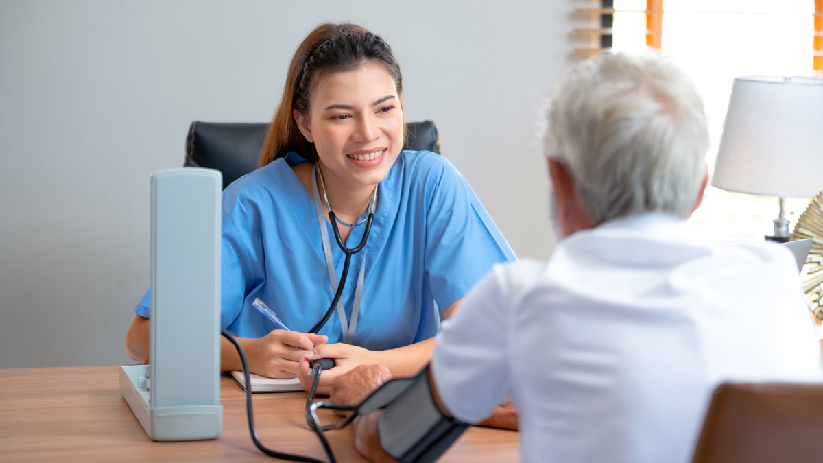Soignante prenant la tension d’un patient âgé
