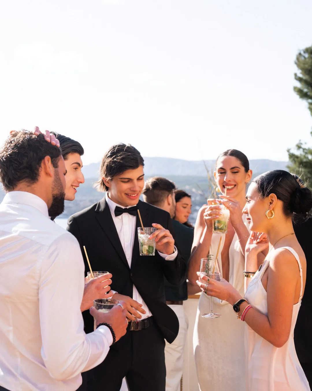 Invités lors d'un événement, cocktails à la main, face à la Provence